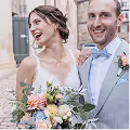 Glückliches Brautpaar Jana und Dirk lachen herzlich – Braut im weißen Trägerkleid mit buntem Brautstrauß, Bräutigam im grauen Anzug mit hellblauer Fliege – Hochzeitsreportage Vavrova Photography Göppingen