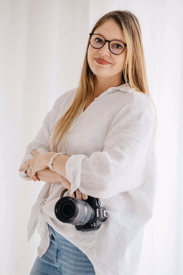 Patricia Bachmann, Hochzeitsfotografin aus Hattenhofen bei Göppingen, lächelt mit ihrer Kamera – Vavrova Photography