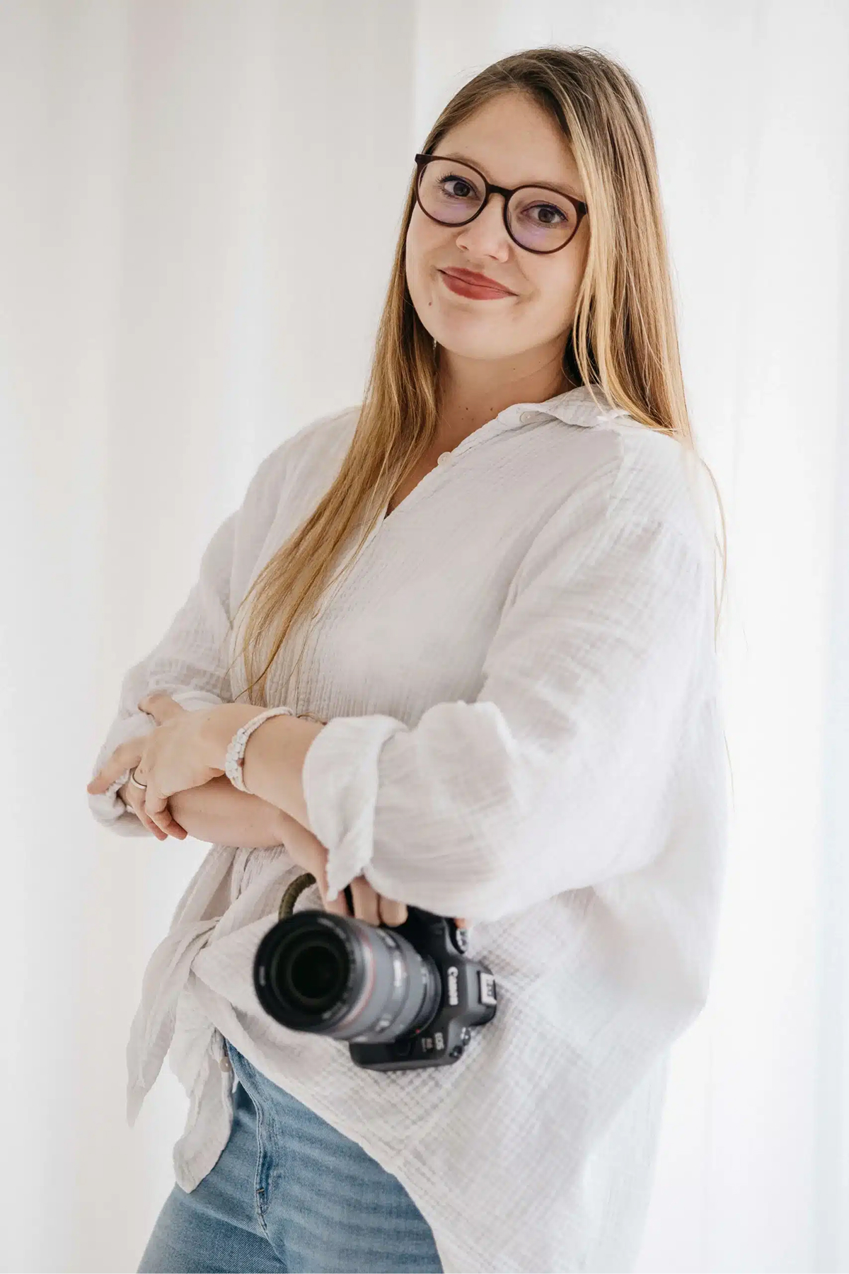 Patricia Bachmann, Hochzeitsfotografin aus Hattenhofen bei Göppingen, lächelt mit ihrer Kamera – Vavrova Photography